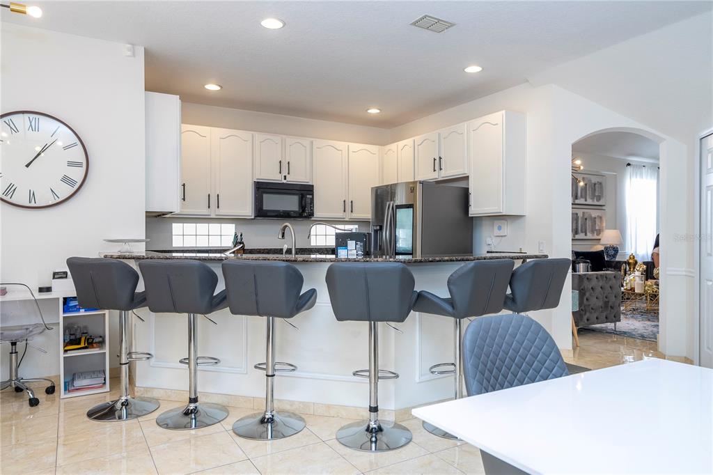 11410 Rapallo Lane Windermere, FL 34786 - Photo 18 of 62 a kitchen with stainless steel appliances kitchen island granite countertop a dining table and chairs