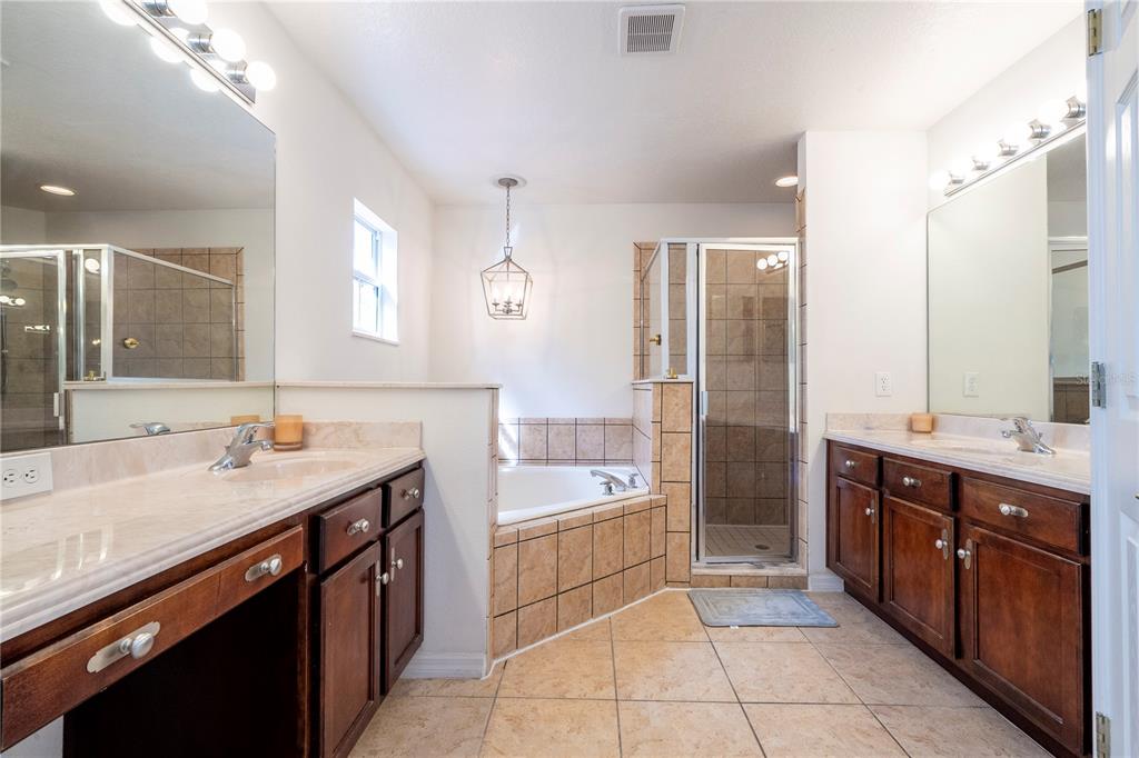 11410 Rapallo Lane Windermere, FL 34786 - Photo 34 of 62 a spacious bathroom with a sink double vanity granite tub shower and a mirror