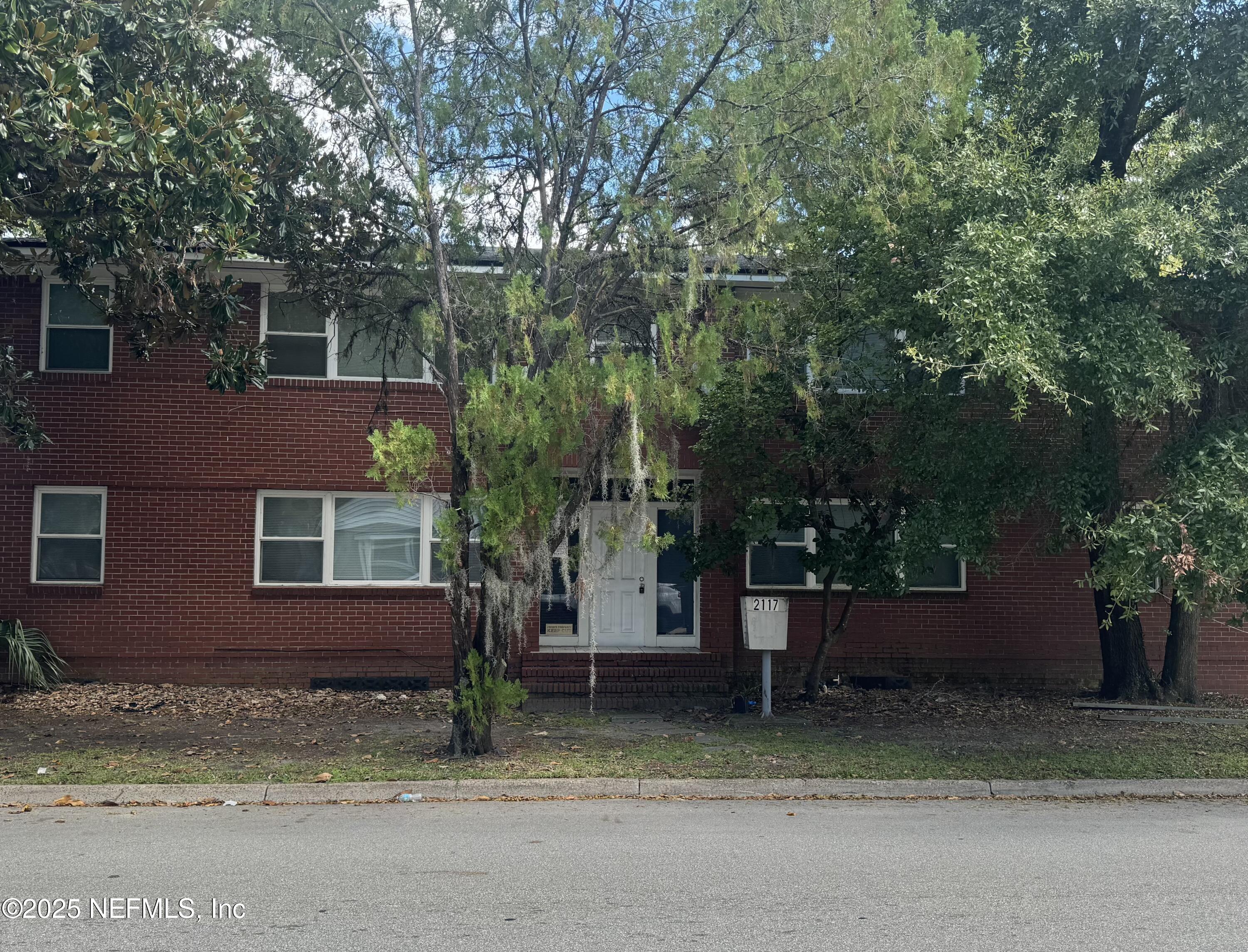 a view of a house with a tree next to a road