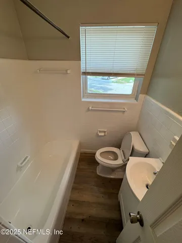 a bathroom with a toilet a sink and a window