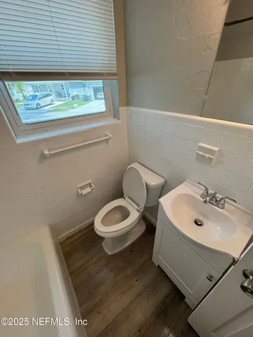 a bathroom with a sink a toilet and a window