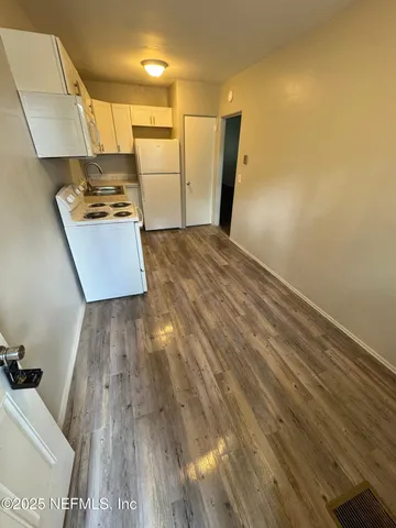 a view of a refrigerator in kitchen and wooden floor