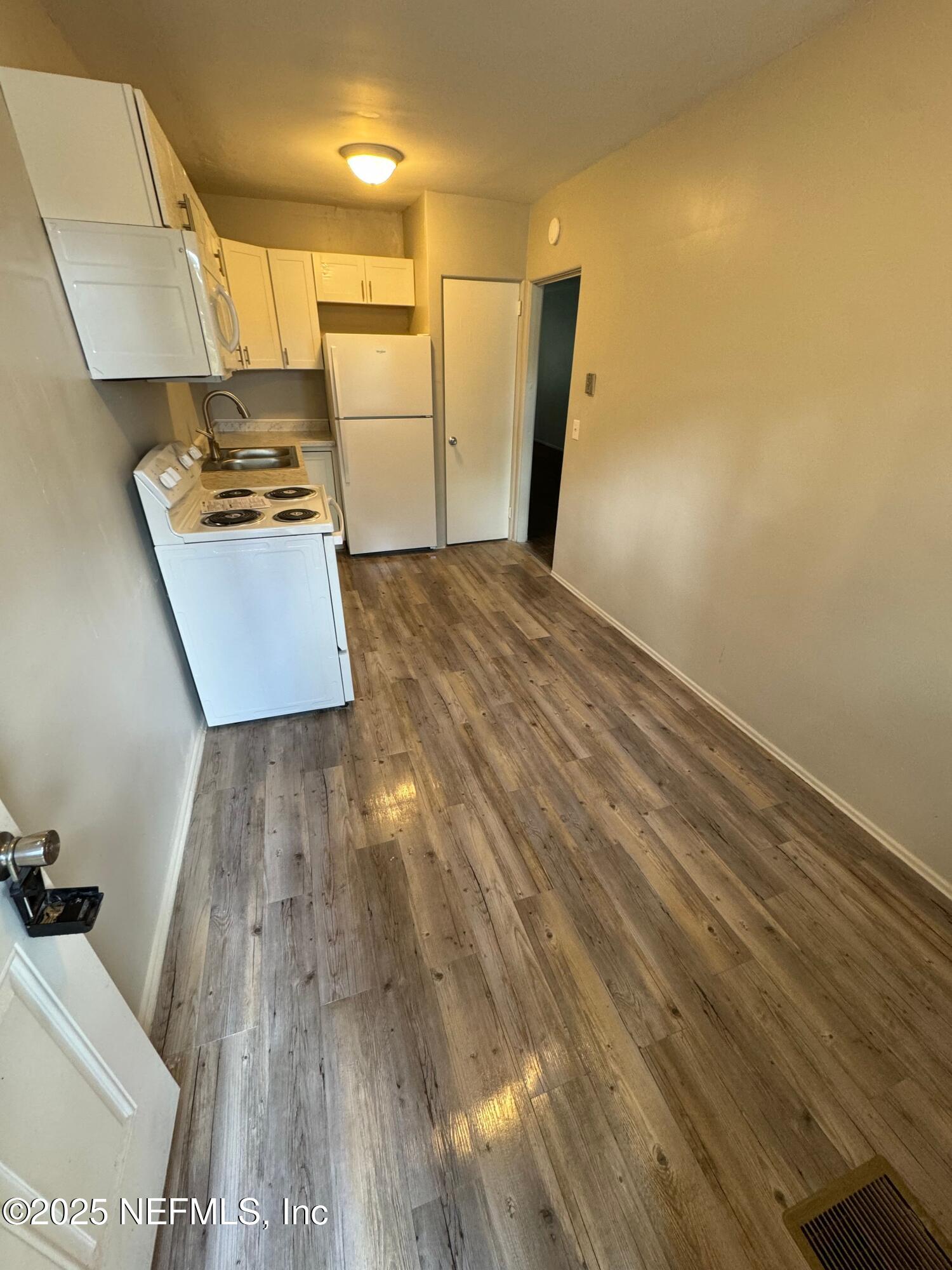 2117 Spring Park Road, Unit 1 Jacksonville, FL 32207 - Photo 9 of 9 a view of a refrigerator in kitchen and wooden floor