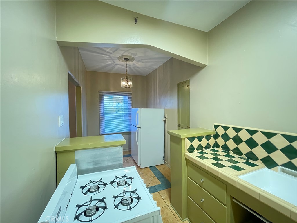 723 East 3rd Street, Unit 12 5 Long Beach, CA 90802 - Photo 7 of 8 a kitchen with a stove and a refrigerator