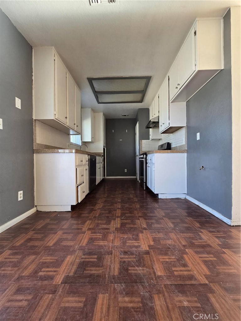 11876 Puye Road Apple Valley, CA 92308 - Photo 7 of 9 a view of a kitchen with a sink and dishwasher a refrigerator with white cabinets