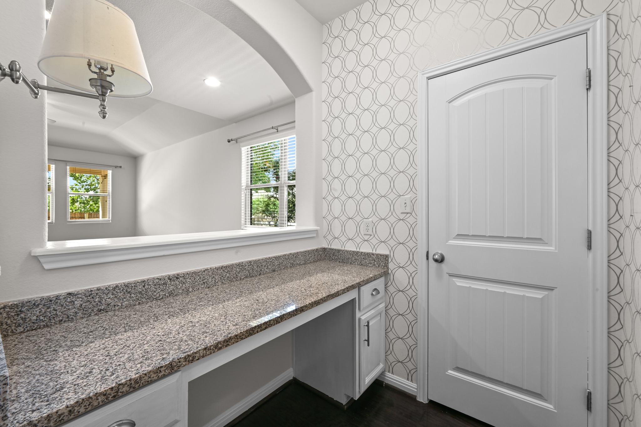 351 Wincliff Drive Buda, TX 78610 - Photo 20 of 40 A clever built-in desk with granite counters provides a functional workspace, illuminated by a window overlooking verdant surroundings.