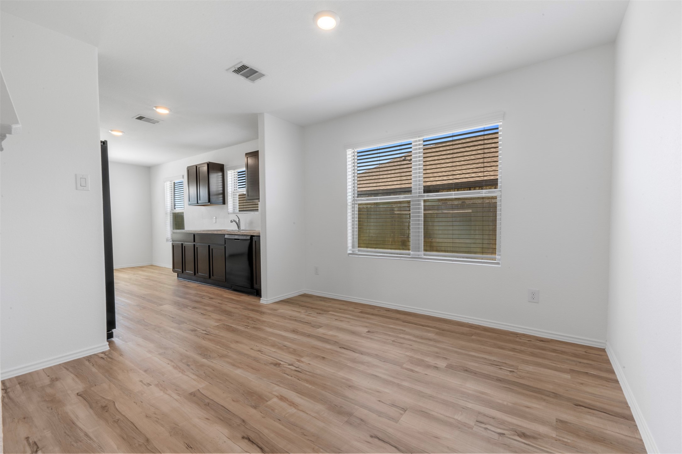 14602 Broadbury Pond Road Rosharon, TX 77583 - Photo 14 of 22 a view of kitchen and empty room with wooden floor