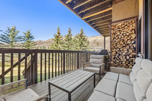 a balcony with wooden floor table and chairs