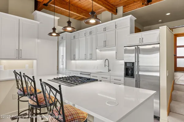 a kitchen with stainless steel appliances granite countertop a sink a stove and a refrigerator