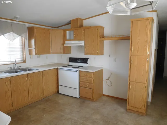 a room with a sink cabinets and a window