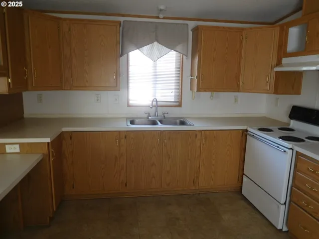 a kitchen with stainless steel appliances a sink a window and cabinets