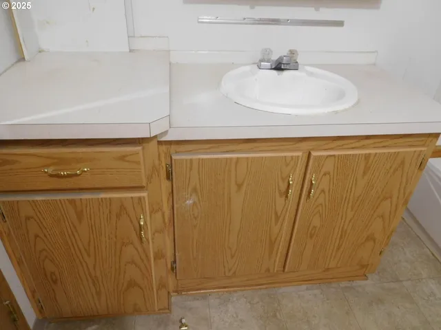 an empty room with wooden floor and cabinet
