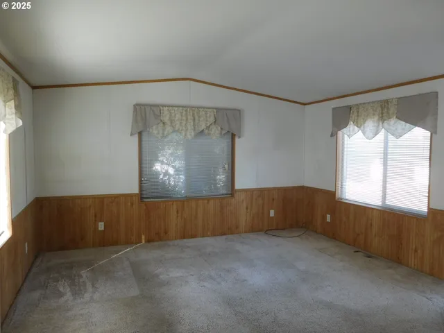a view of an empty room with a fireplace and a window