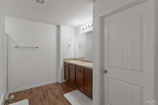 a bathroom with a granite countertop sink a mirror and a shower