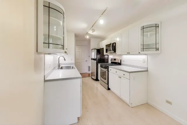a kitchen with a sink stove and cabinets