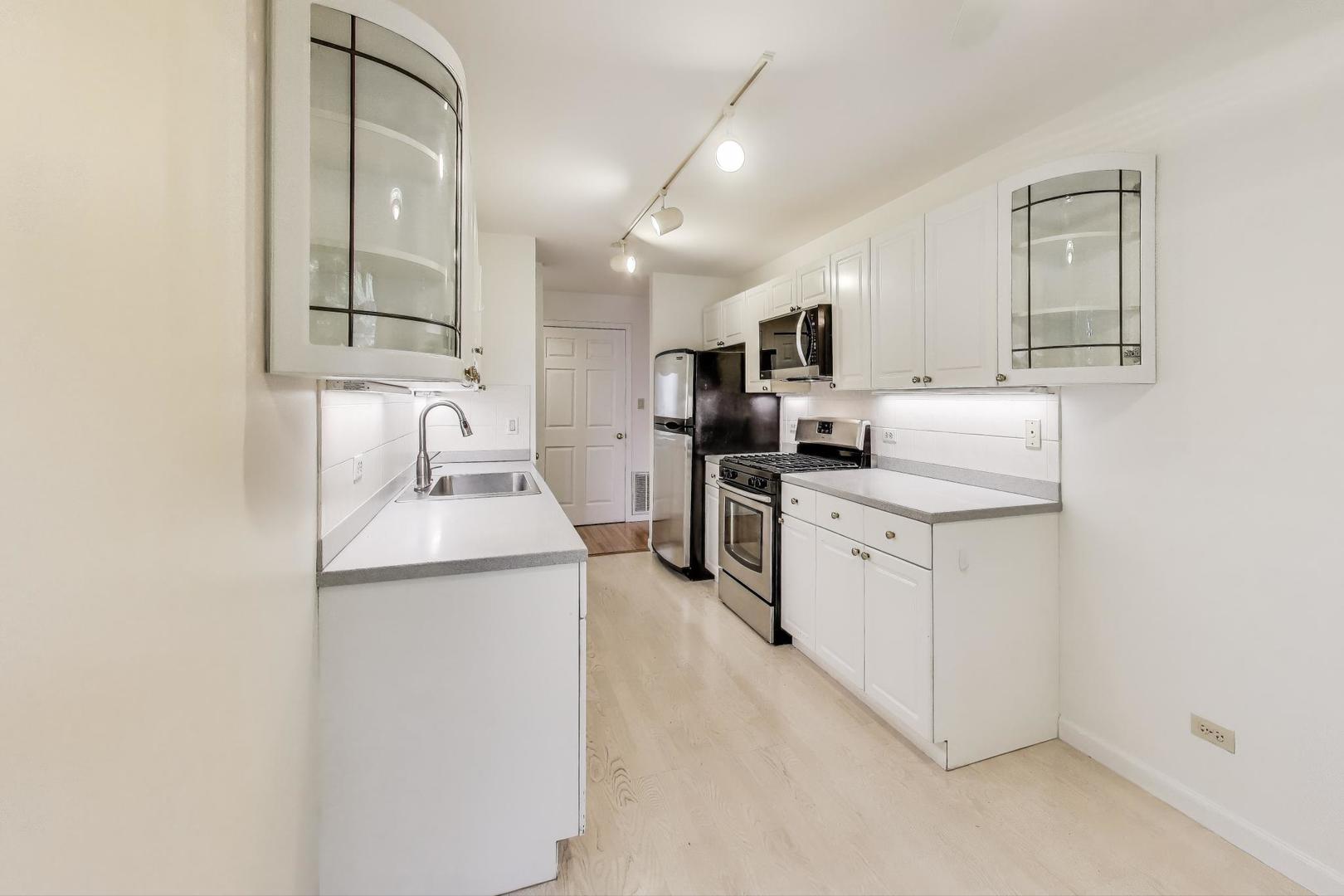 2720 Central Street, Unit 4C Evanston, IL 60201 - Photo 11 of 25 a kitchen with a sink stove and cabinets