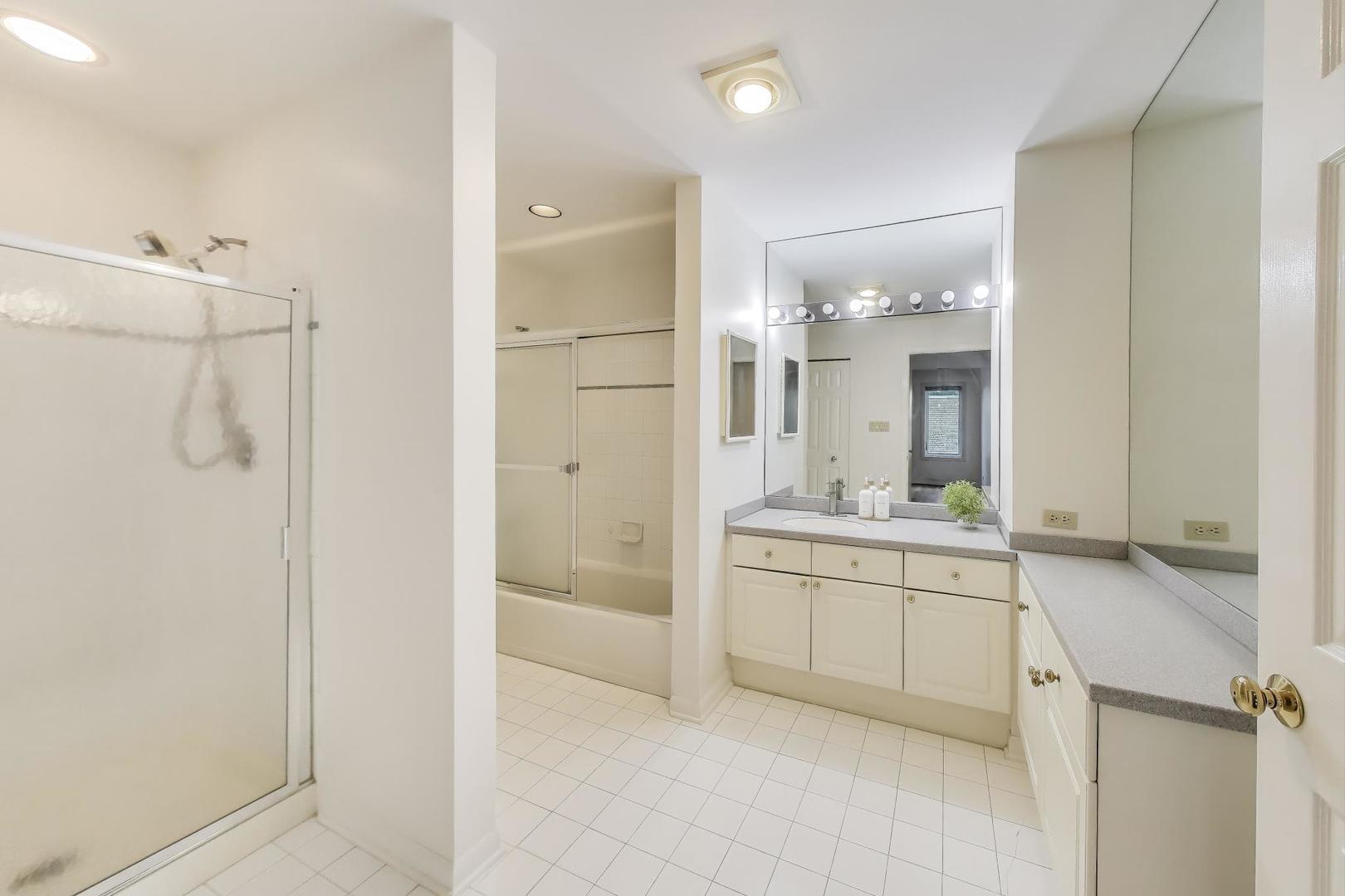 2720 Central Street, Unit 4C Evanston, IL 60201 - Photo 14 of 25 a bathroom with a granite countertop sink a mirror and a shower