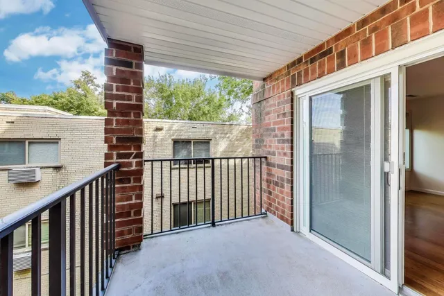 a view of a balcony with wooden floor and iron fence