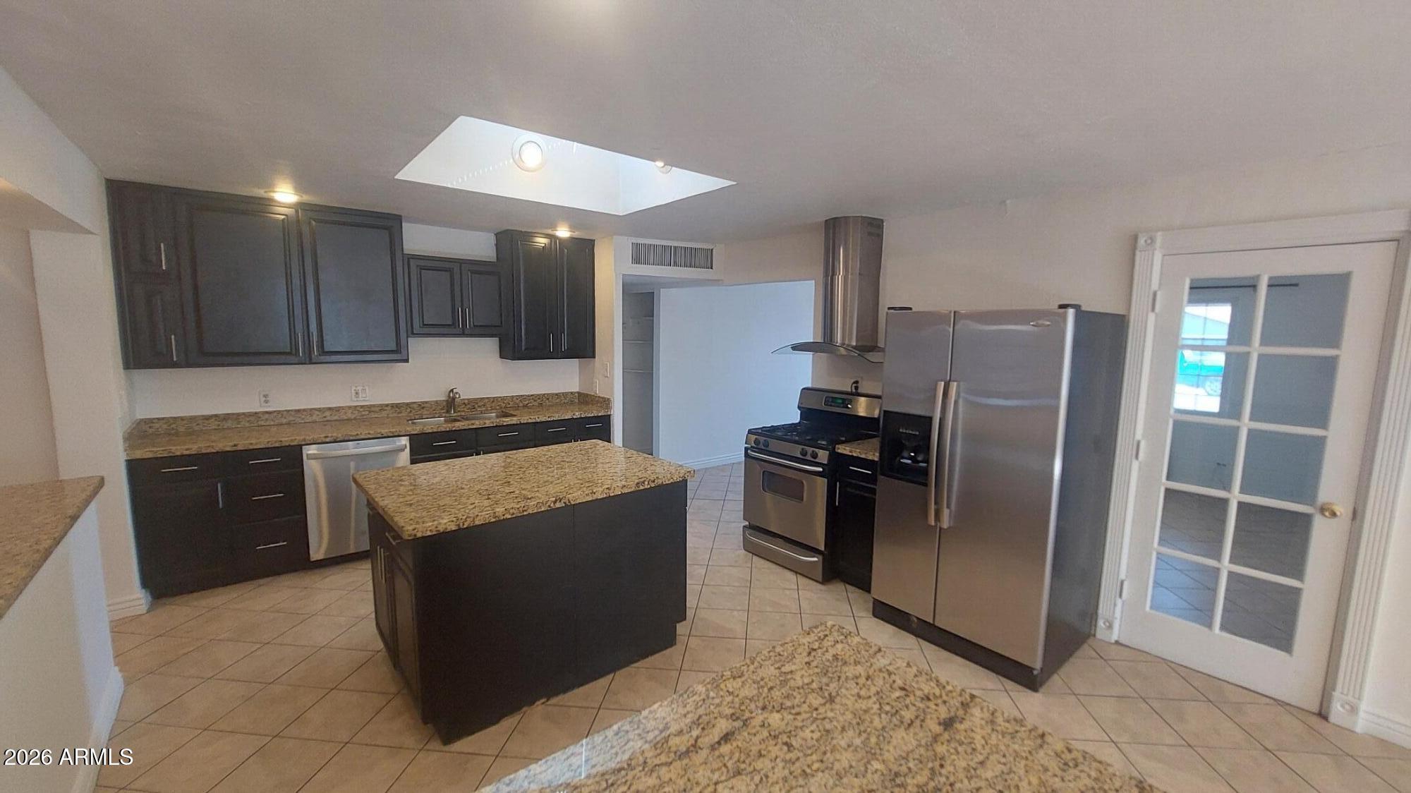2448 West Freeway Lane Phoenix, AZ 85021 - Photo 9 of 27 a kitchen with stainless steel appliances granite countertop a stove a refrigerator and a sink