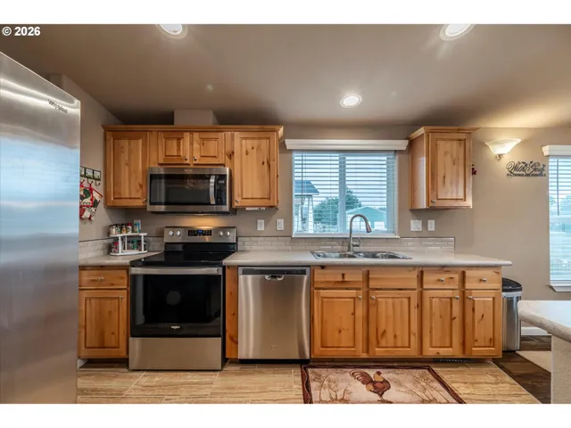 a kitchen with stainless steel appliances granite countertop a stove a sink and a microwave