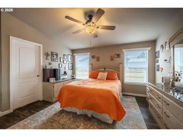 a bedroom with a bed and dresser with mirror