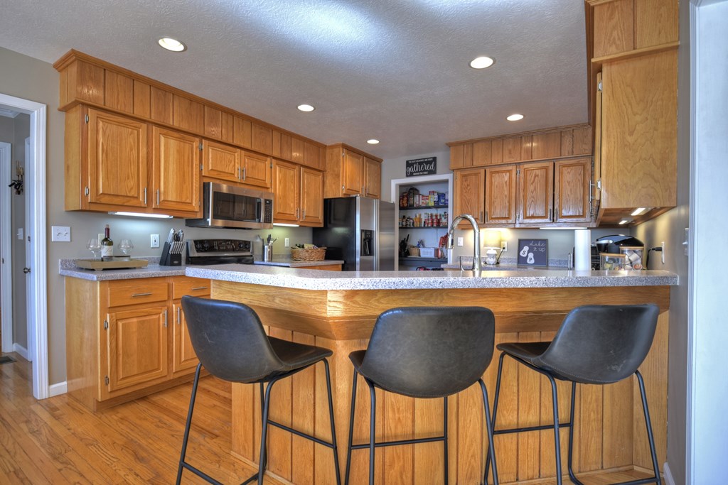 3725 Ada Street Blue Ridge, GA 30513 - Photo 12 of 75 a kitchen with stainless steel appliances granite countertop a stove a sink a microwave a refrigerator and chairs