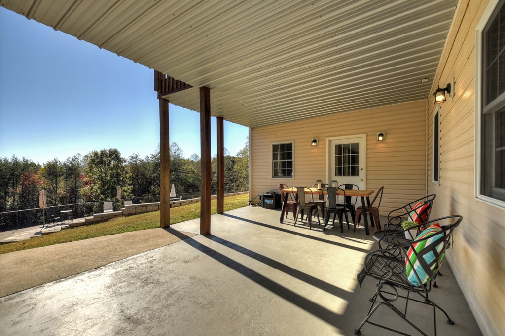 3725 Ada Street Blue Ridge, GA 30513 - Photo 53 of 75 a view of a patio with table and chairs with wooden floor and fence