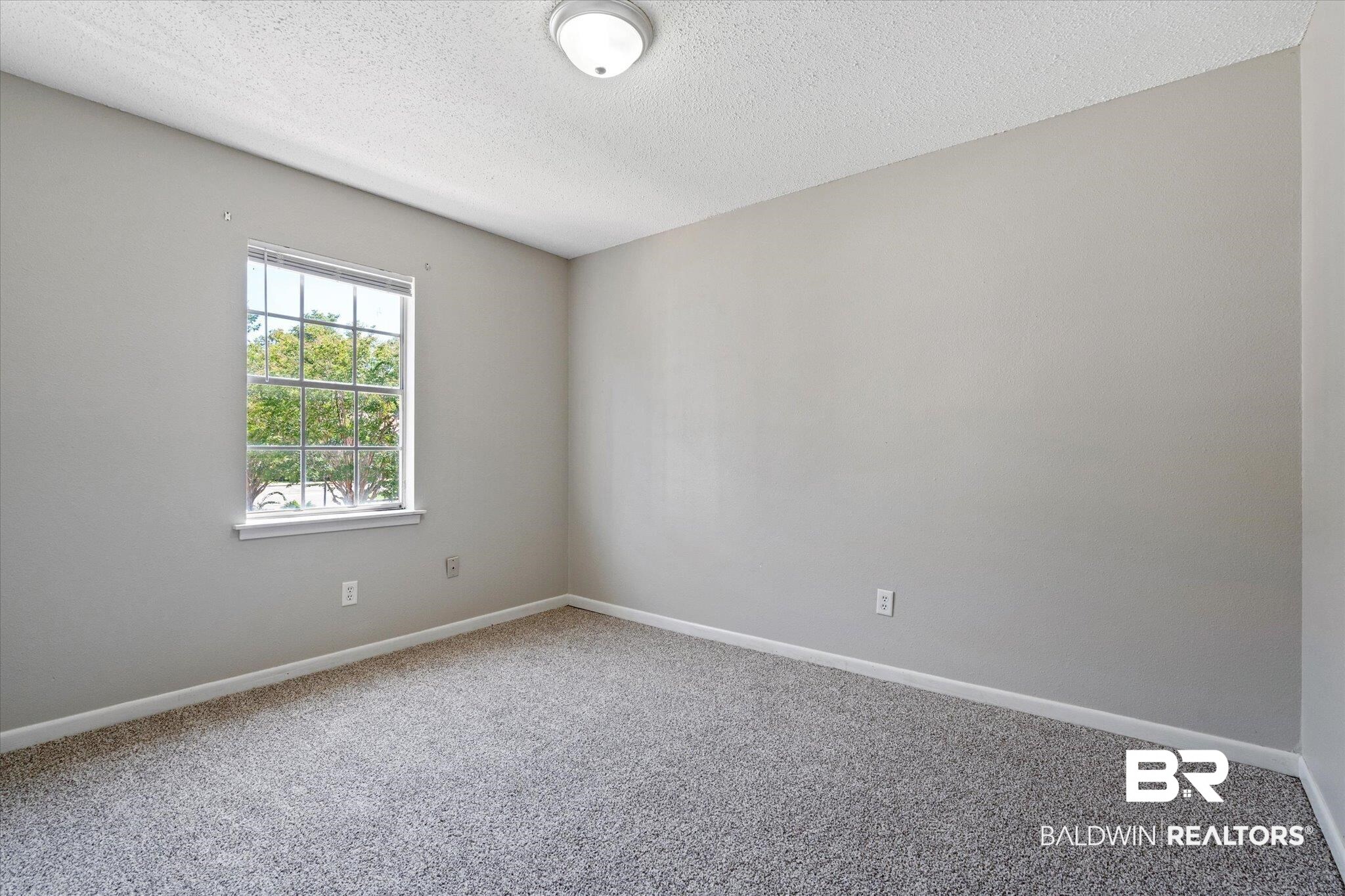 4017 Cottage Hill Road, Unit 59 Mobile, AL 36609 - Photo 17 of 25 Carpeted empty room with a textured ceiling