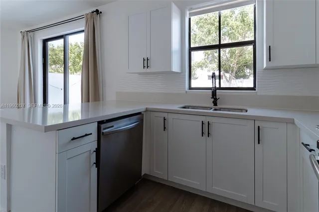 a kitchen with a sink window and cabinets
