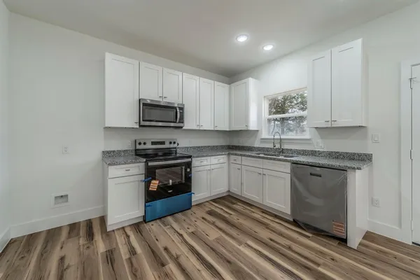 a kitchen with granite countertop cabinets stainless steel appliances and a sink