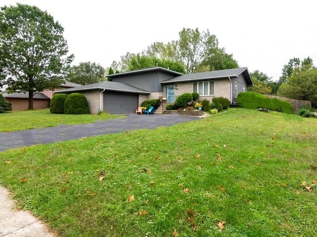 a view of a house with a yard and sitting area