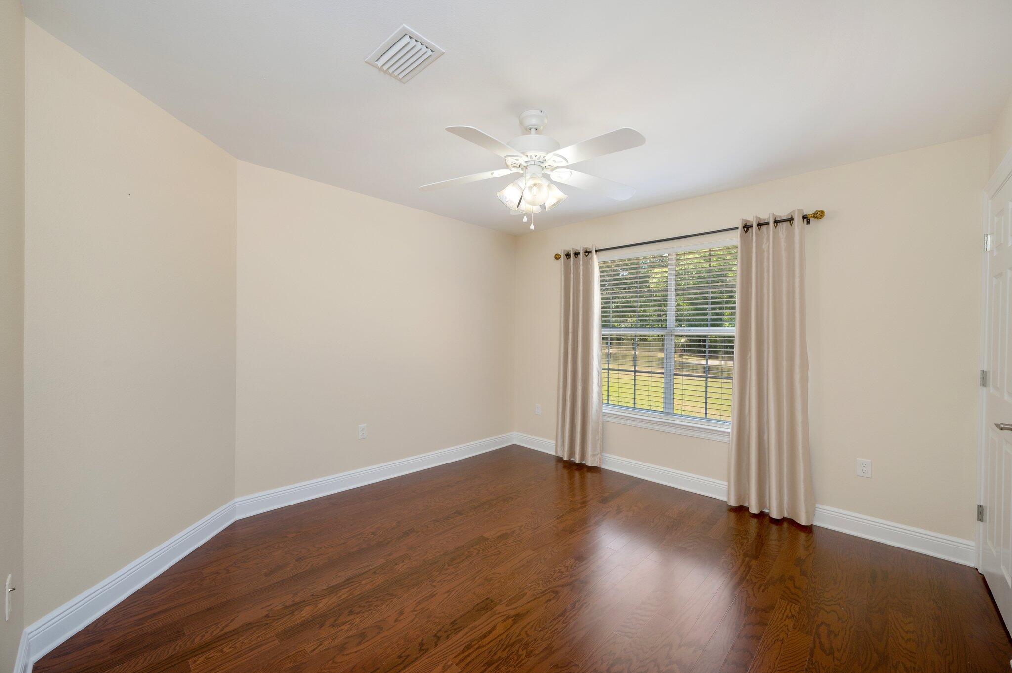 5777 Buckward Road Baker, FL 32531 - Photo 27 of 60 an empty room with wooden floor and windows