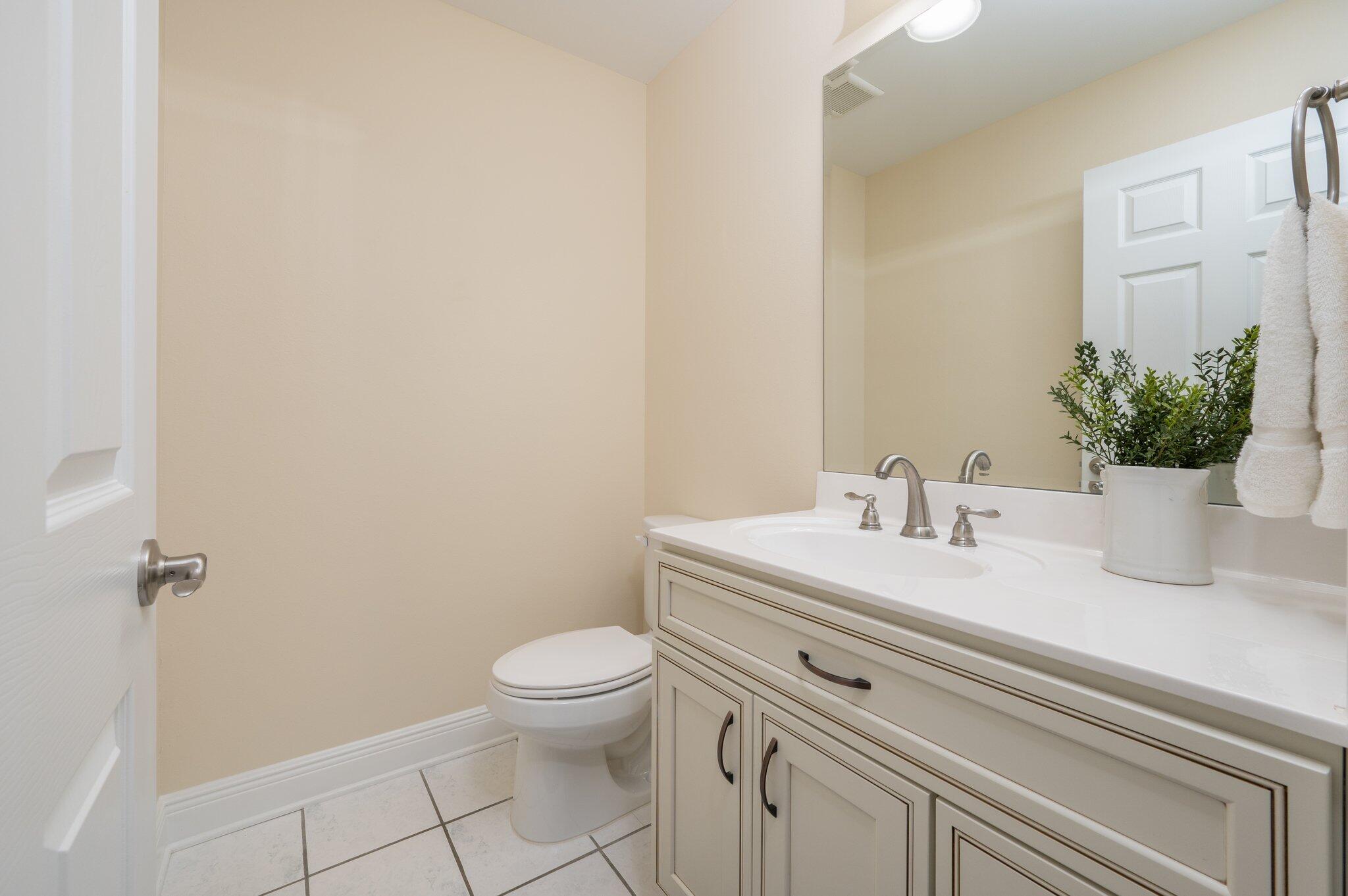 5777 Buckward Road Baker, FL 32531 - Photo 29 of 60 a bathroom with a granite countertop toilet sink and mirror