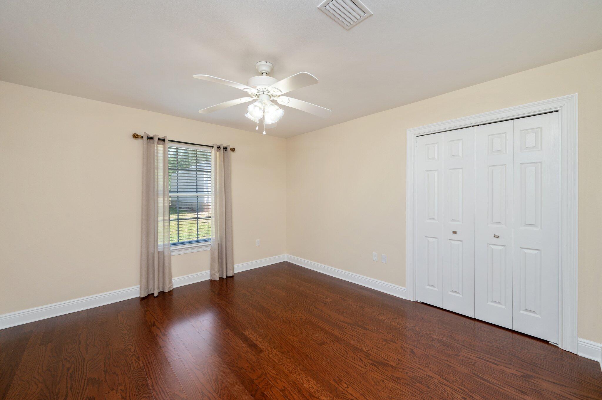 5777 Buckward Road Baker, FL 32531 - Photo 40 of 60 an empty room with wooden floor fan and windows