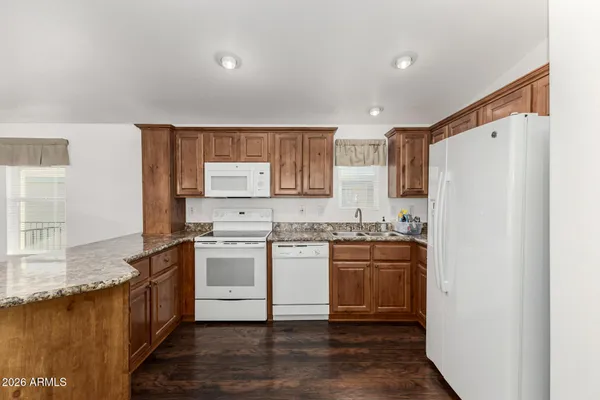 a view of a kitchen with wooden floor and a ceiling fan
