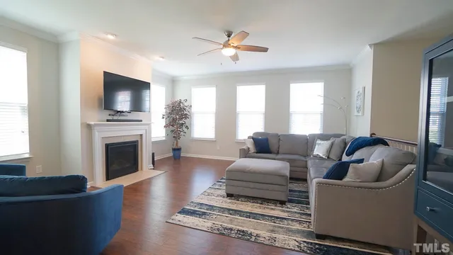 a living room with furniture a flat screen tv and a fireplace