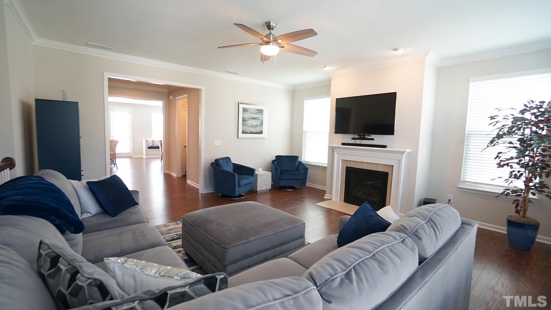540 Metro Station Apex, NC 27502 - Photo 16 of 45 a living room with furniture a fireplace and a flat screen tv