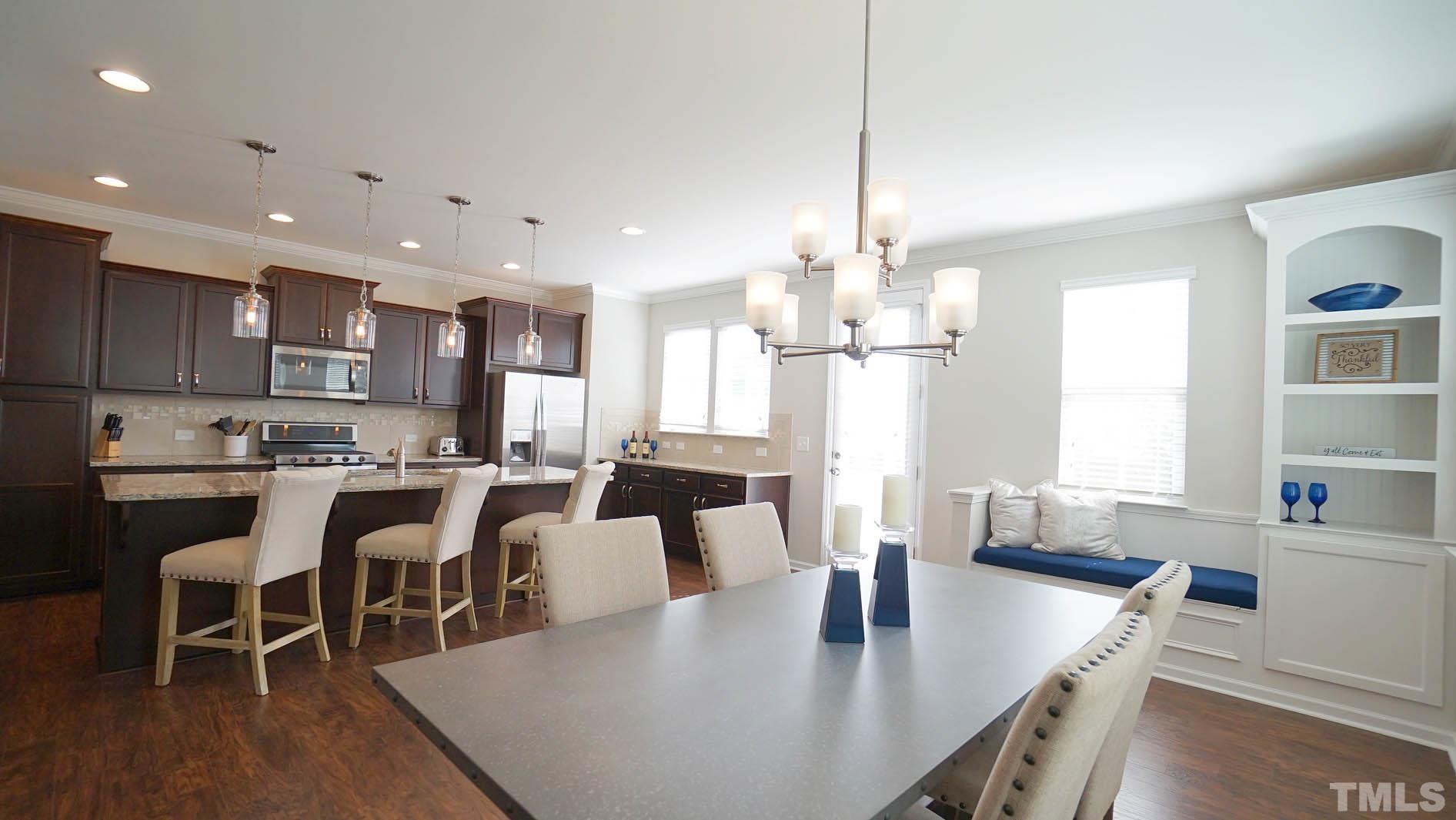 540 Metro Station Apex, NC 27502 - Photo 25 of 45 a large kitchen with kitchen island a dining table and chairs