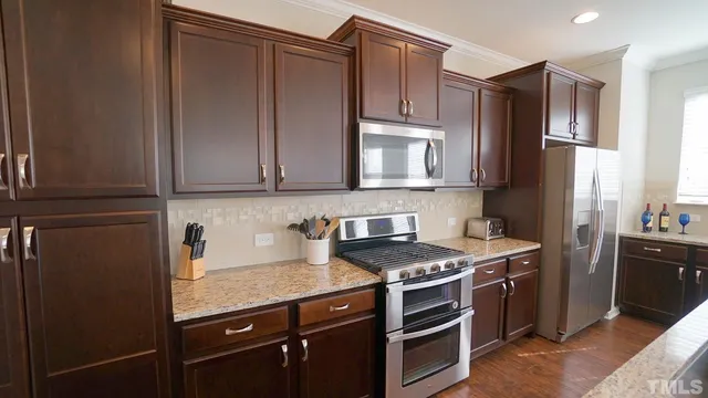 a kitchen with stainless steel appliances granite countertop a stove a refrigerator and a sink
