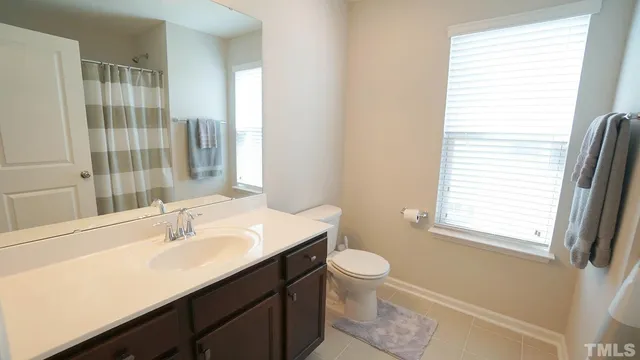 a bathroom with a sink a toilet and a window