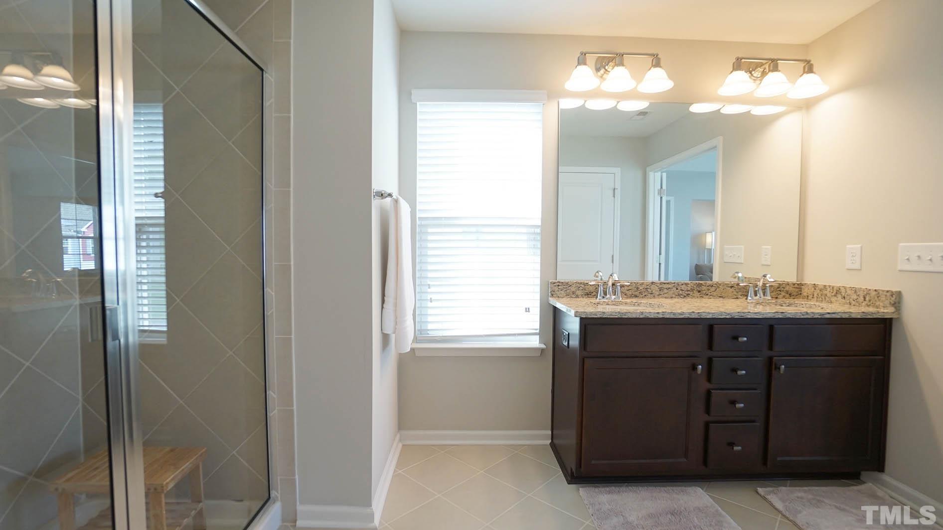 540 Metro Station Apex, NC 27502 - Photo 41 of 45 a bathroom with a granite countertop sink a mirror and a shower