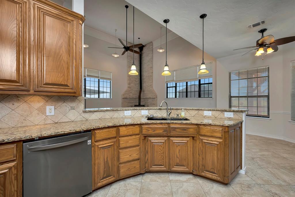 5520 White Settlement Road Weatherford, TX 76087 - Photo 22 of 39 a kitchen with granite countertop a sink a counter space appliances and cabinets