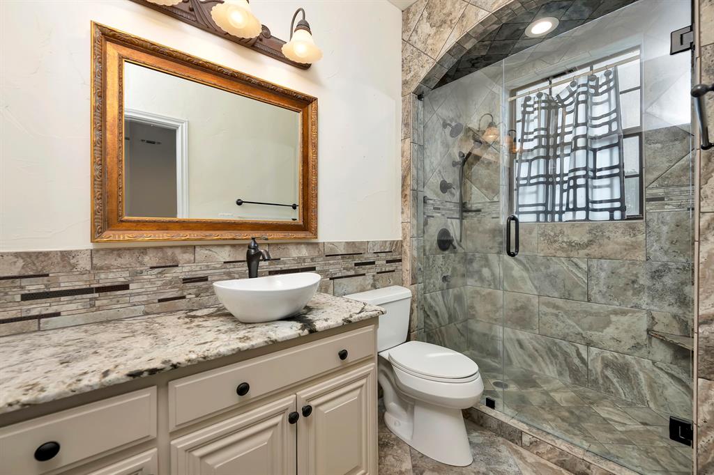 5520 White Settlement Road Weatherford, TX 76087 - Photo 26 of 39 a bathroom with a granite countertop sink a toilet and a mirror