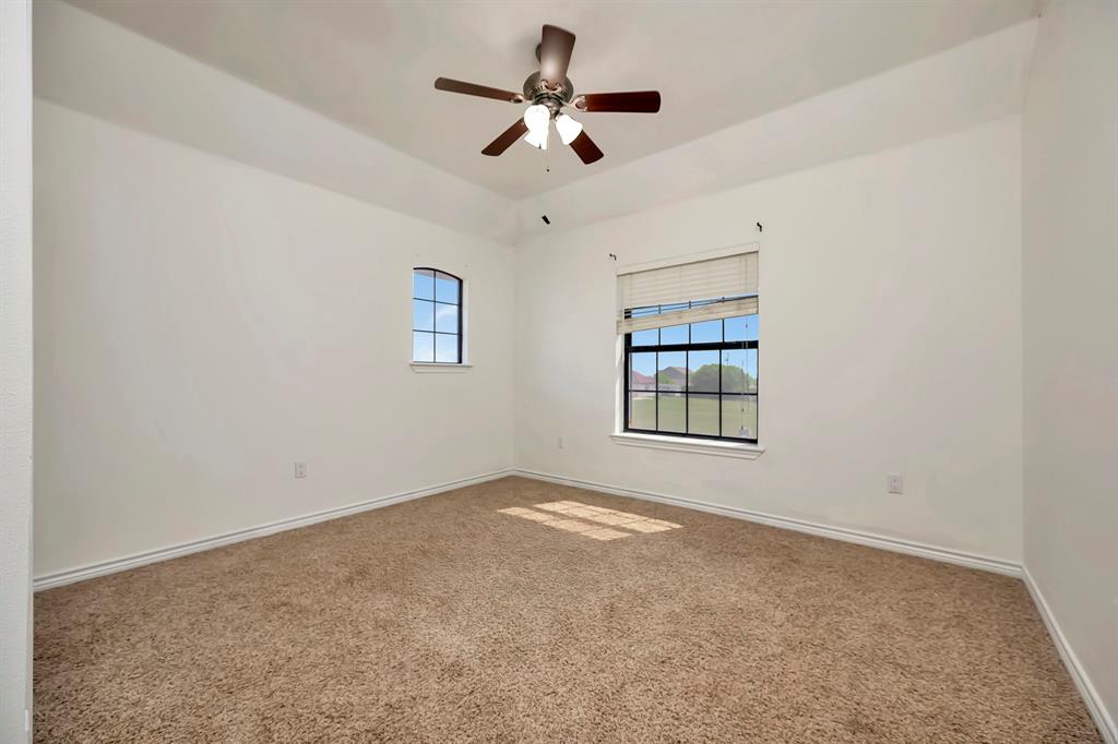 5520 White Settlement Road Weatherford, TX 76087 - Photo 34 of 39 Carpeted empty room featuring baseboards and ceiling fan