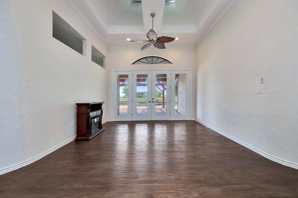 5520 White Settlement Road Weatherford, TX 76087 - Photo 6 of 39 Unfurnished living room featuring dark wood-style floors, french doors, a towering ceiling, and crown molding