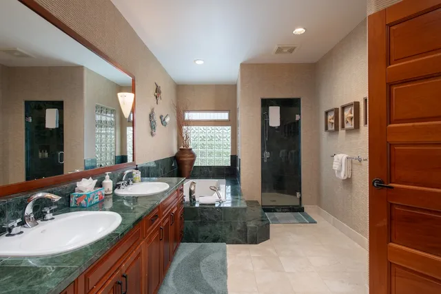 a spacious bathroom with a granite countertop sink and a mirror