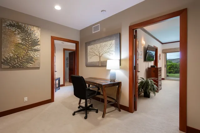 a view of a workspace with furniture and a window