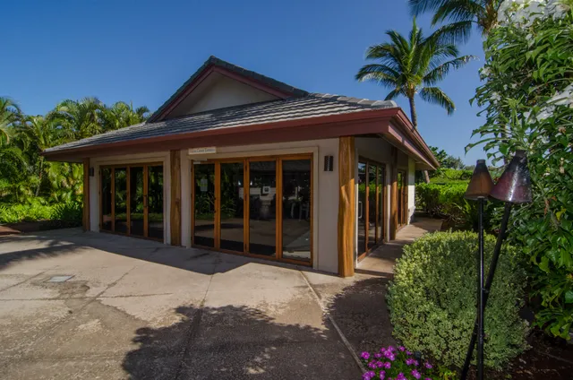 a view of a house with a small yard and potted plants