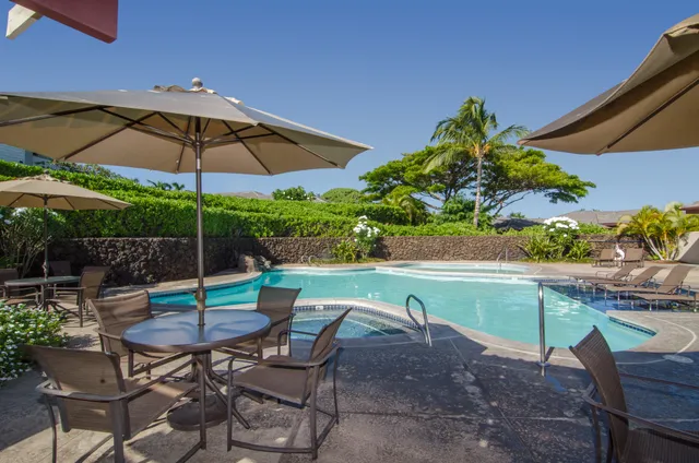a view of patio with chairs and table under an umbrella