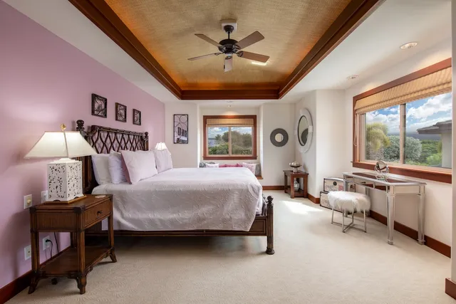 a spacious bedroom with a bed a table and a chandelier